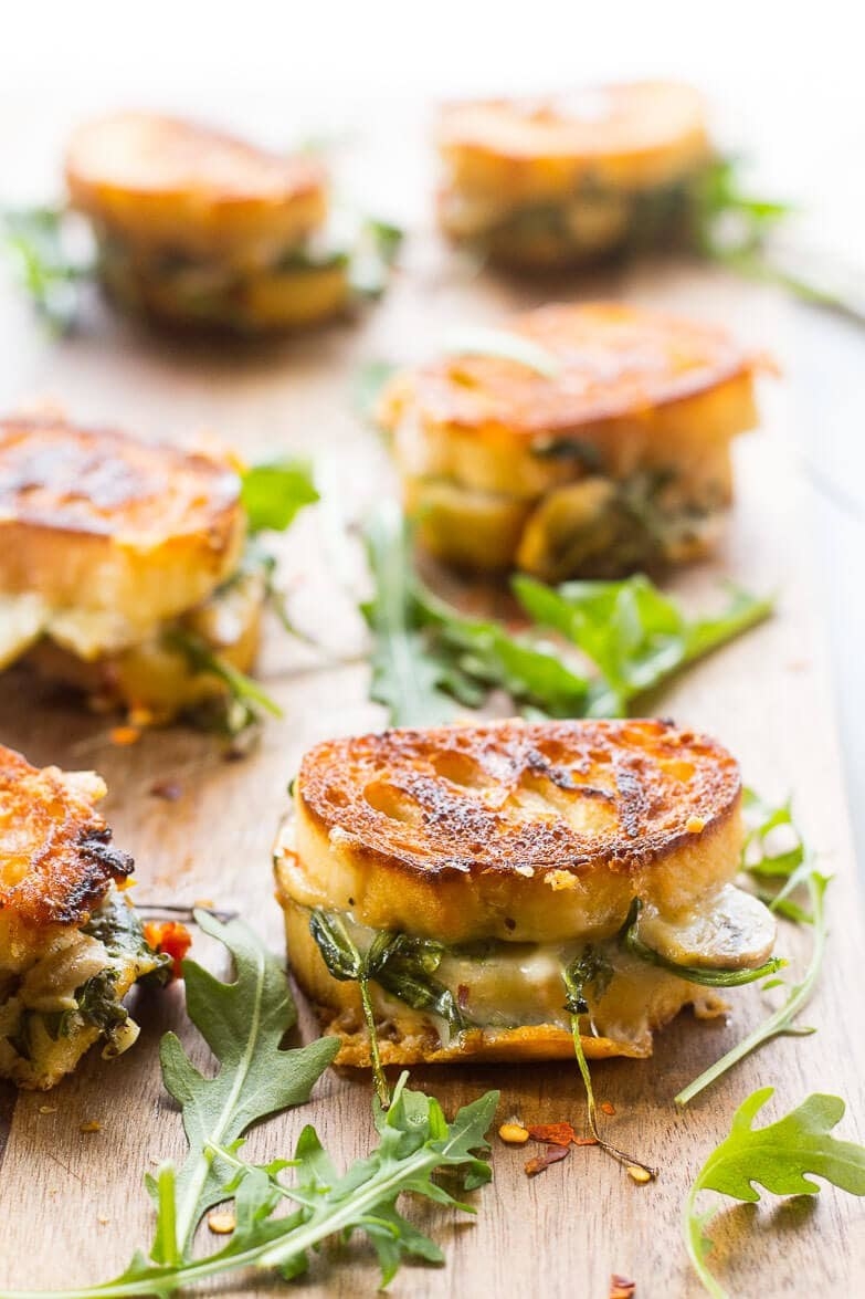 Mini grilled cheese sandwiches with arugula.