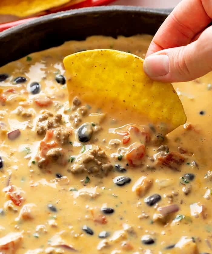 Dipping a chip into loaded queso.