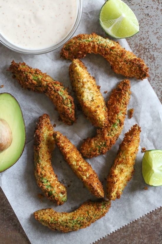 Breaded avocado fries on parchment paper.