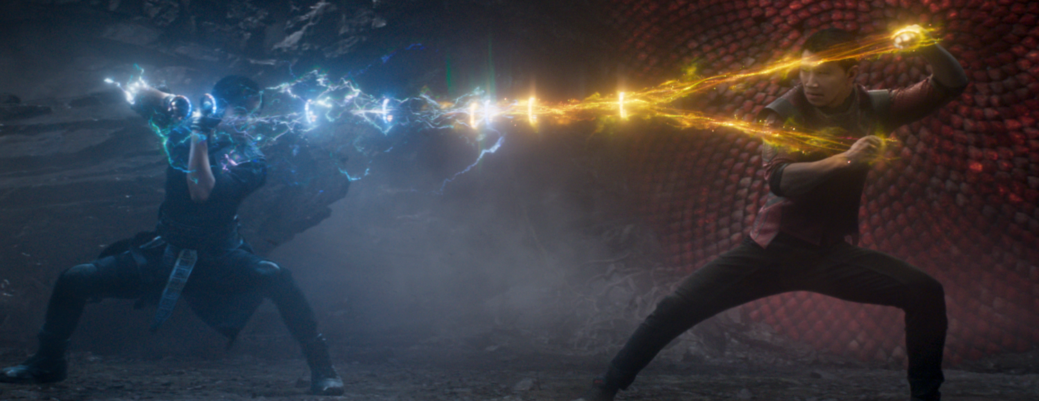 Shang-Chi and Wenwu battling as the ten rings are pulled between them, with blue light coming from Wenwu and gold light coming from Shang-Chi