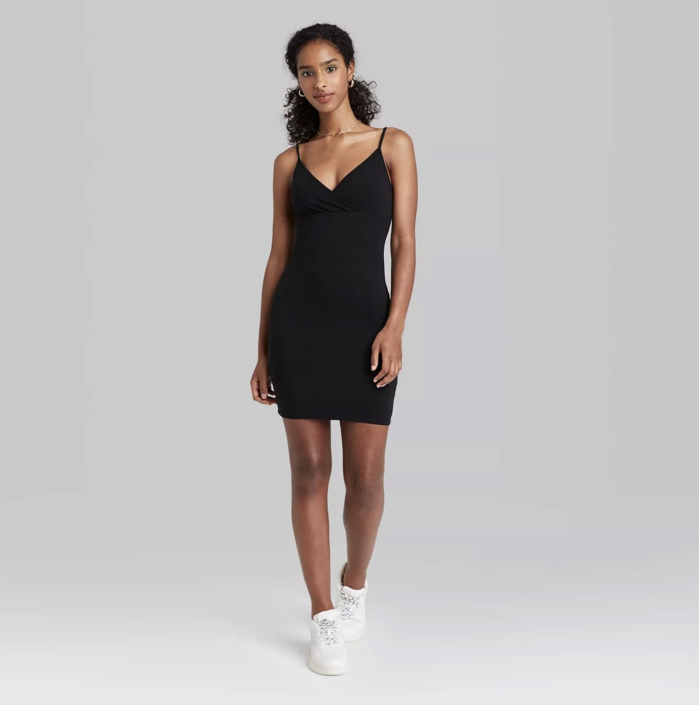 The black knit dress has a v-neck, spaghetti straps and falls mid-thigh