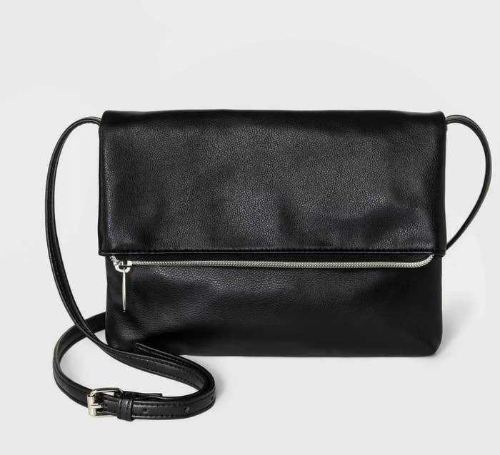 The black crossbody bag has a silver zip closure and long black strap