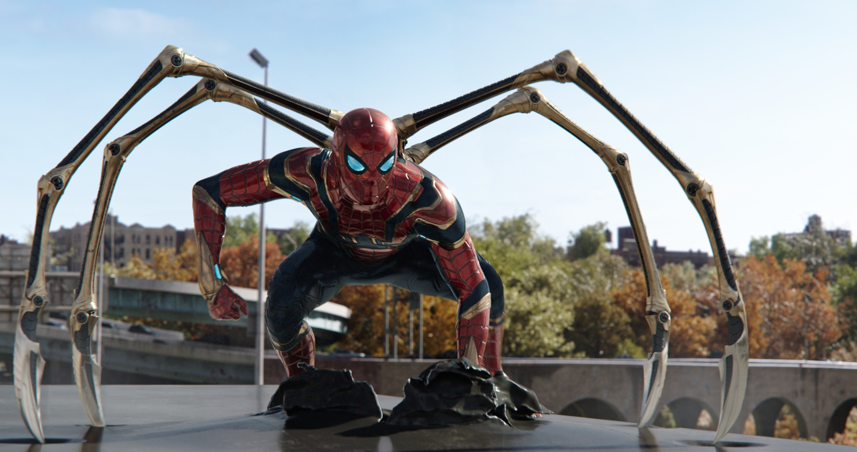 Spider-Man crouching in his Iron Spider suit, with the four metal arms out either side of him