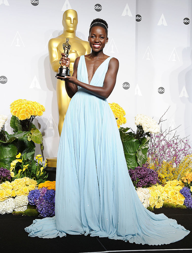 Nyong&#x27;o posing in the blue gown with her Oscar