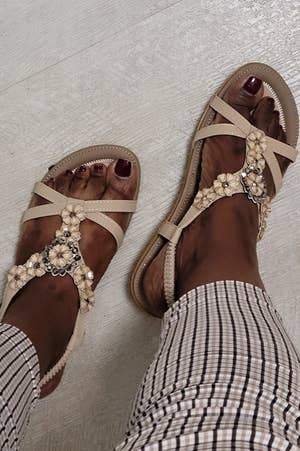 Reviewer photo of them wearing the beige embellished sandals