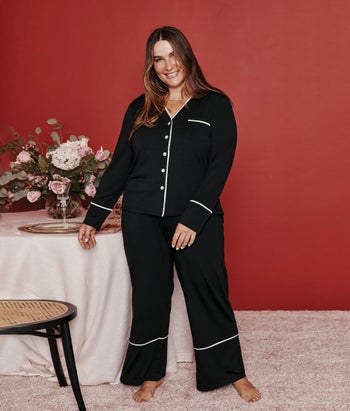 model wearing black longsleeve pajamas with white piping