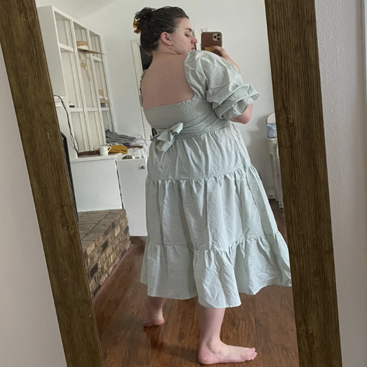 A customer review photo of them showing the back of the dress while they wear it