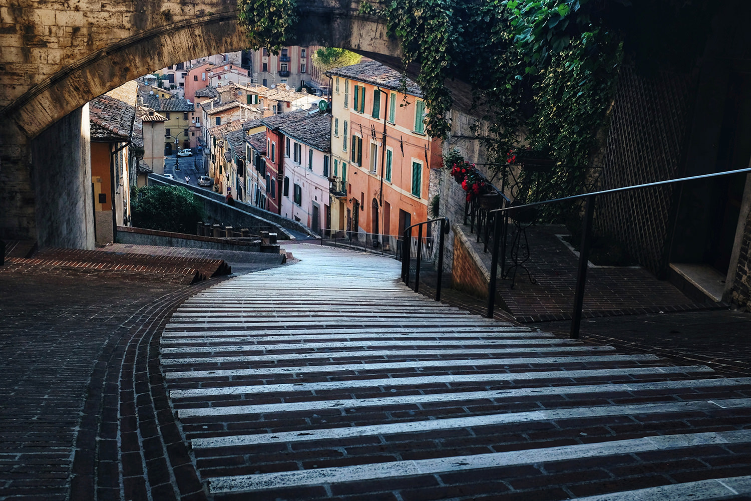 A steep, winding road under a bridge in Perugia