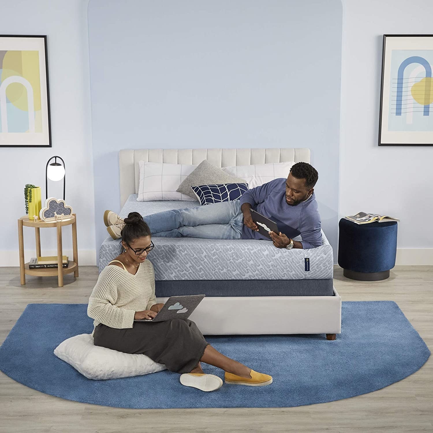 Man laying on 9-inch mattress next to woman sitting on floor