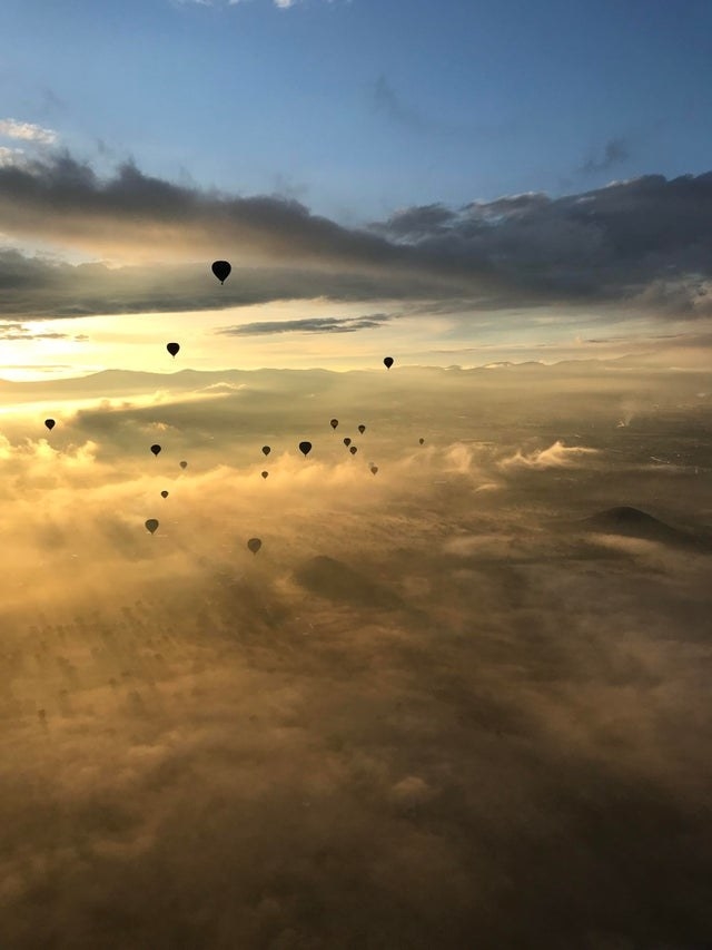hot air ballons float above the clouds in Mexico