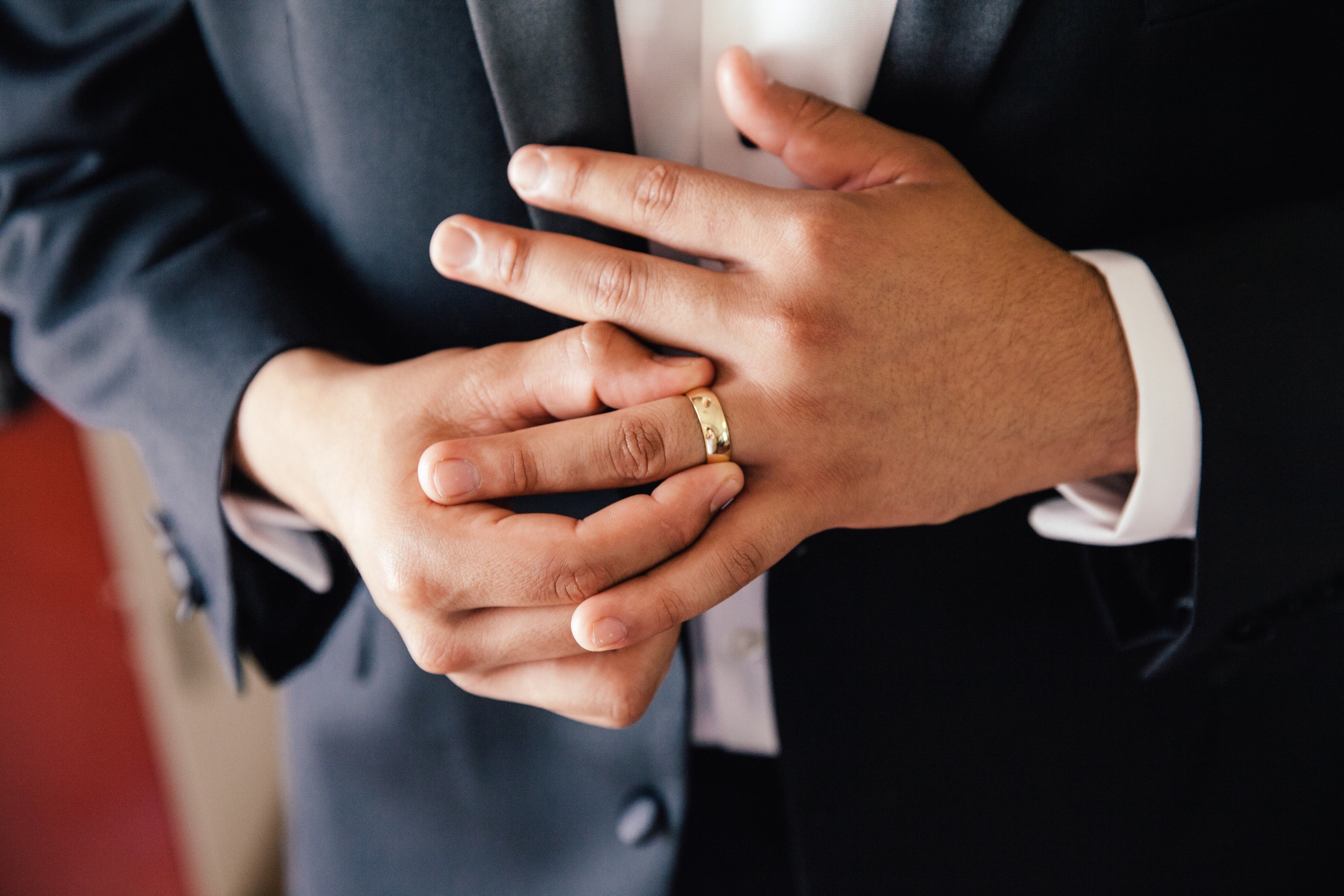 A groom adjusts his wedding ring