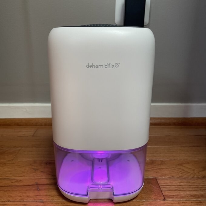 reviewer&#x27;s picture of the dehumidifier with purple lights