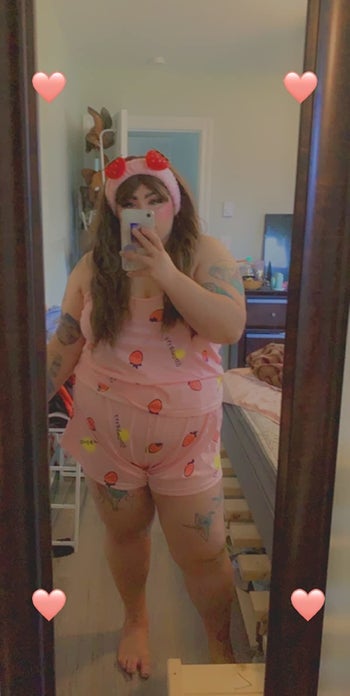 reviewer mirror selfie wearing the pink pajama shorts with strawberries on it