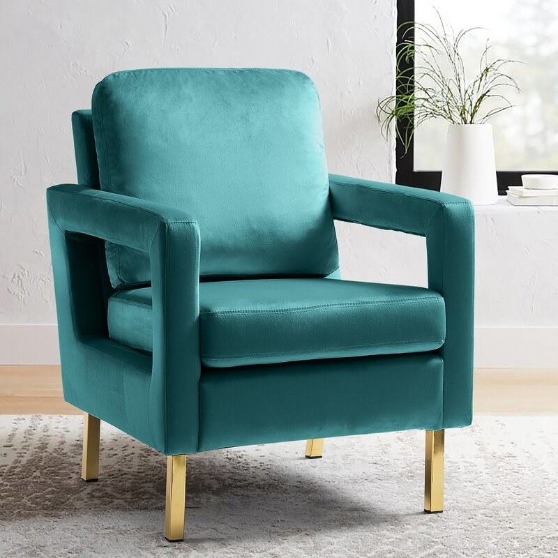 The accent chair in teal velvet with gold legs
