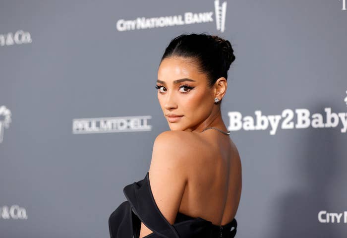 Shay looking over her shoulder while posing for photos on the red carpet of an event