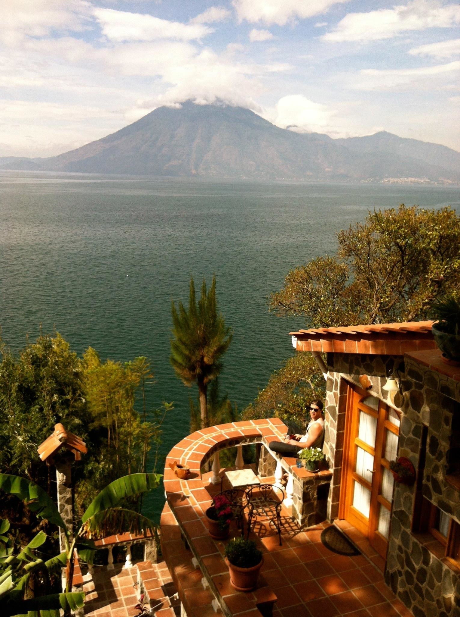 Person on patio overlooking water and volcano