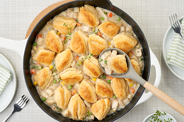 Large pot of chicken and biscuits on table