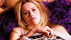 Reese Witherspoon as Elle Woods picks a chocolate out of a box and eats it in &quot;Legally Blonde&quot;