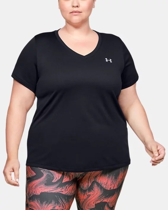 A person wearing the t-shirt with some patterned leggings in front of a plain background