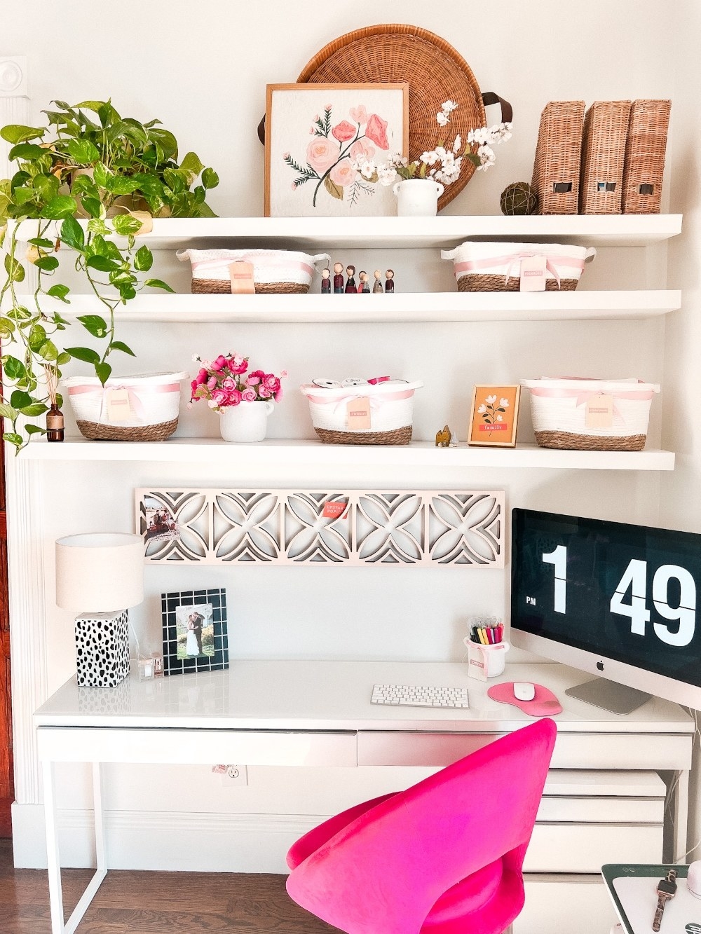 blogger&#x27;s work desk with three long shelves holding decor above the desk