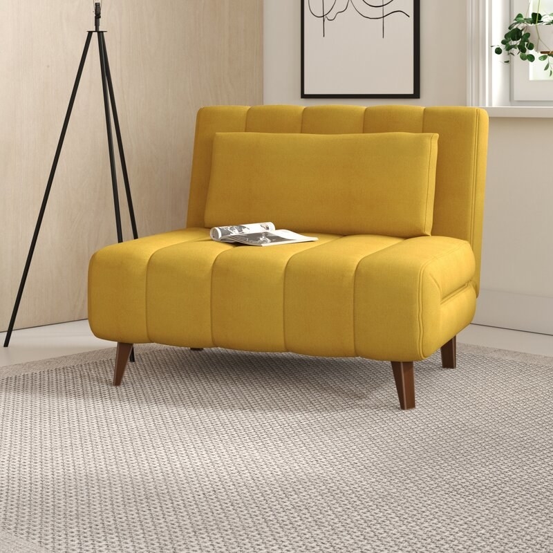 Yellow convertible chair with pillow and brown legs