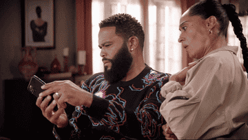 Anthony Anderson as Dre Johnson and Tracee Ellis Ross as Bow Johnson look at a cell phone and gasp in &quot;Black-ish