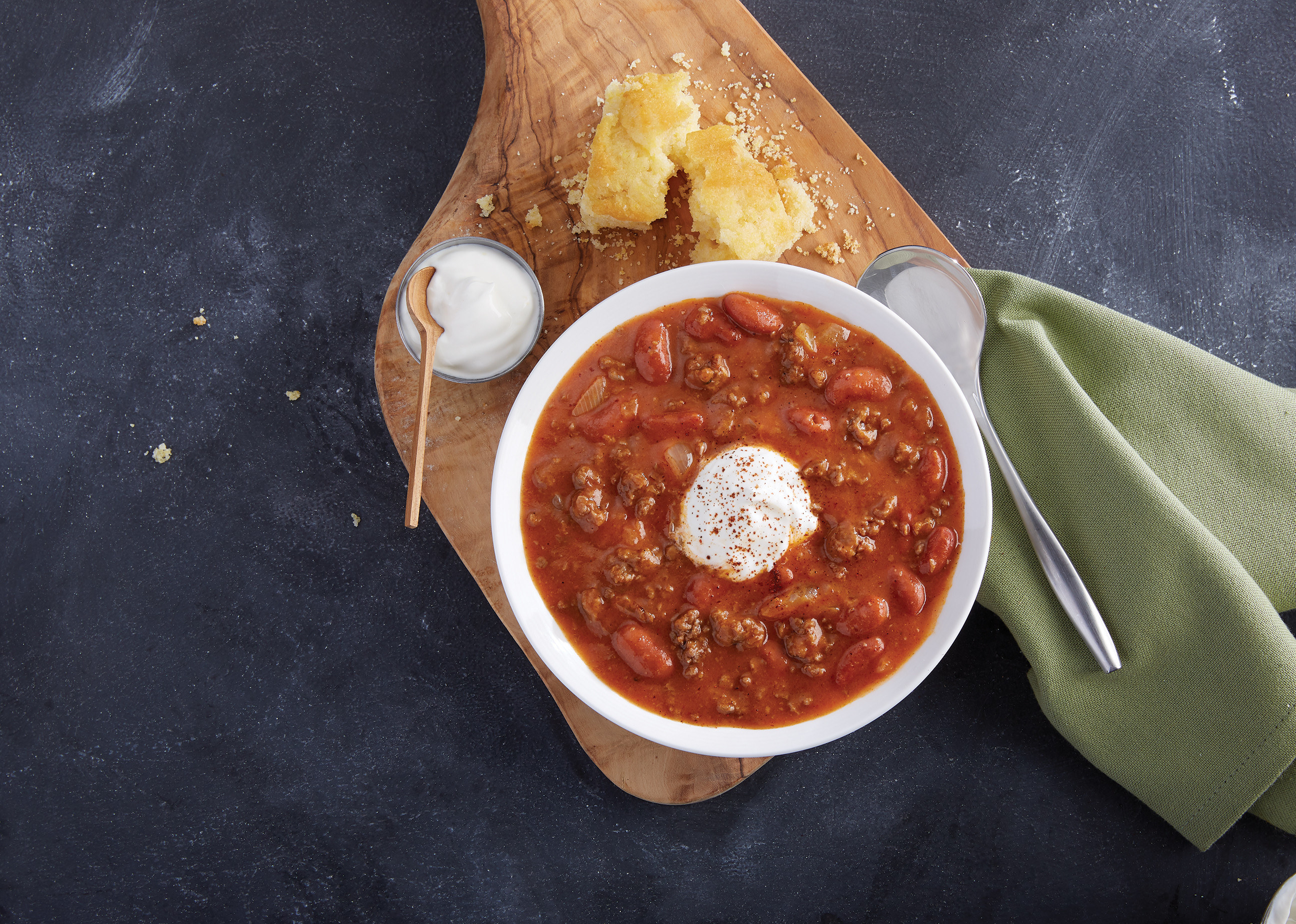 Meatless chili beside sour cream and cornbread