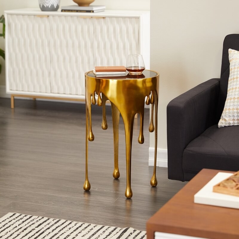 A side table that looks like gold paint dripping.