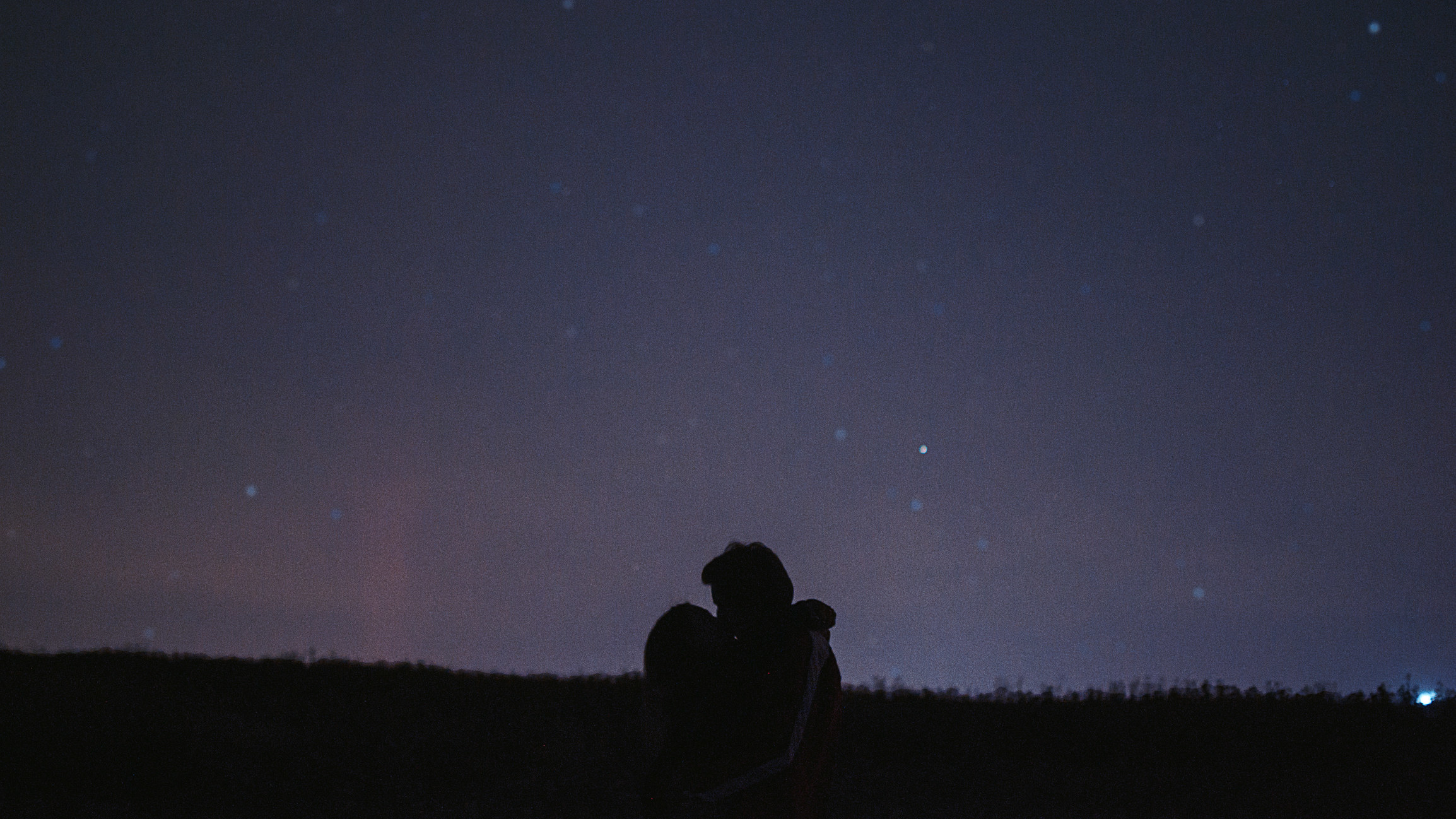 Couple under starry sky hugging