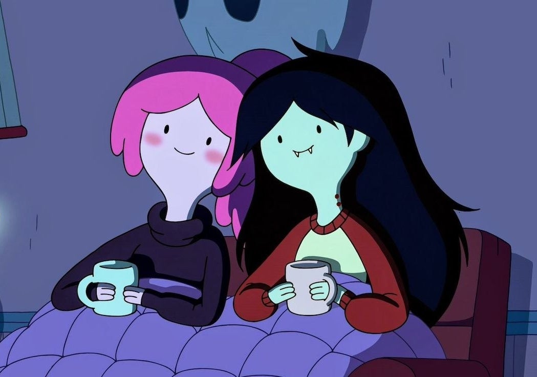 Bubblegum and Marceline sat next to each other on a sofa with a blanket over their legs, both holding mugs