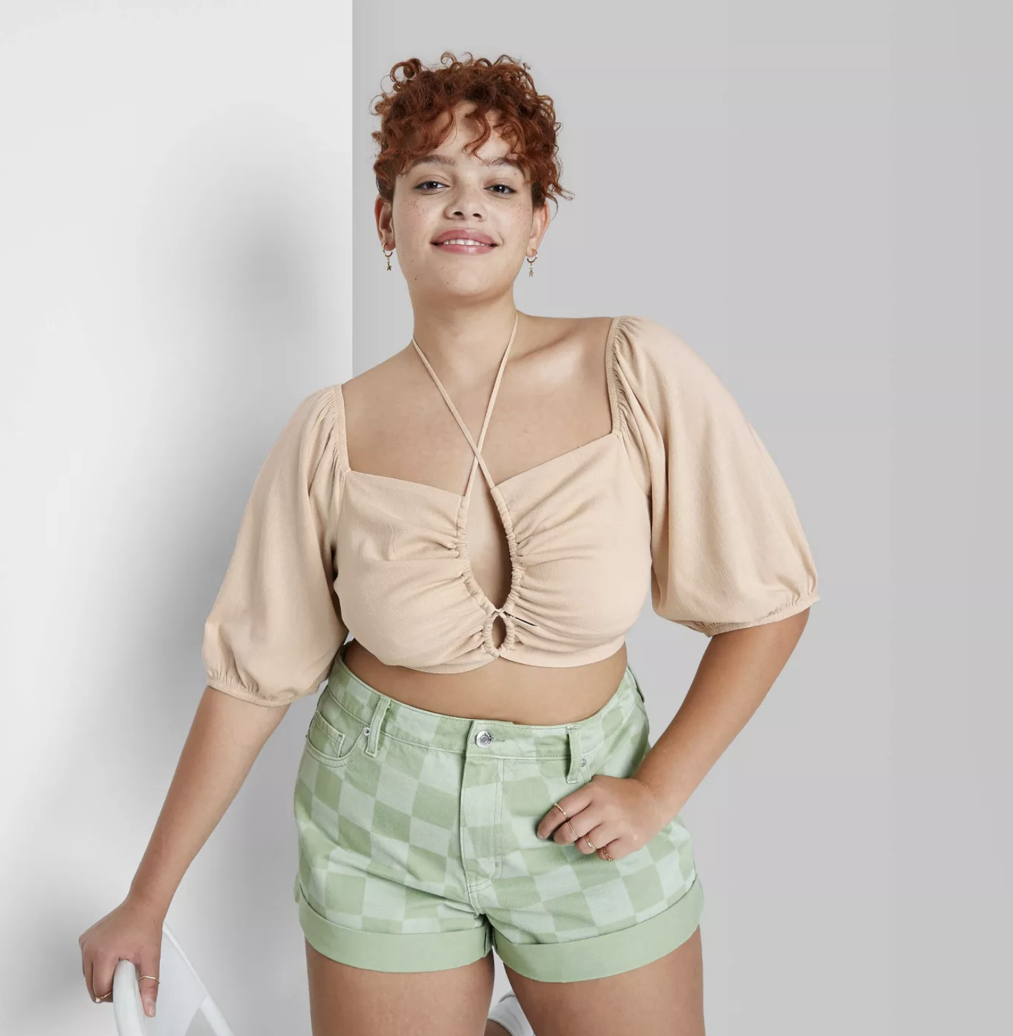 model wearing the top in tan with green checkered shorts