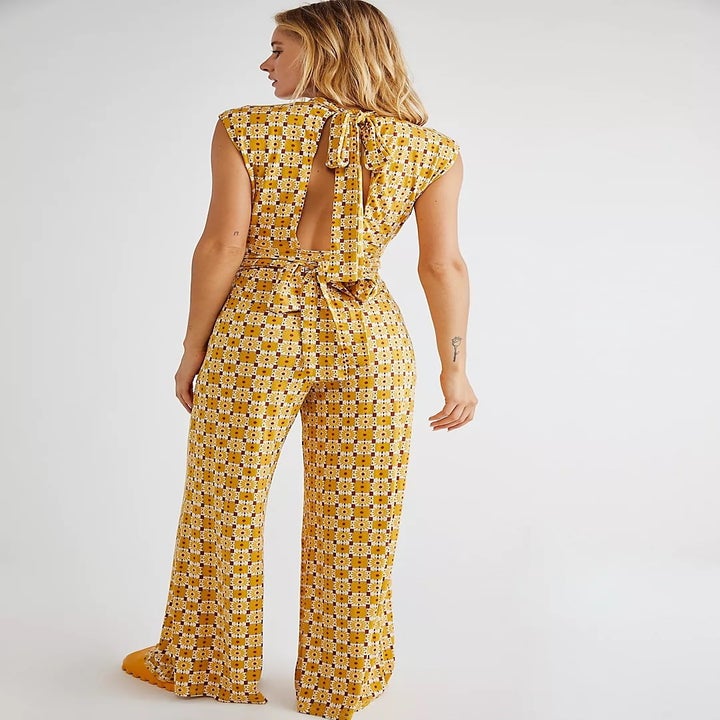back of model wearing the yellow jumpsuit, showing the tie at the back