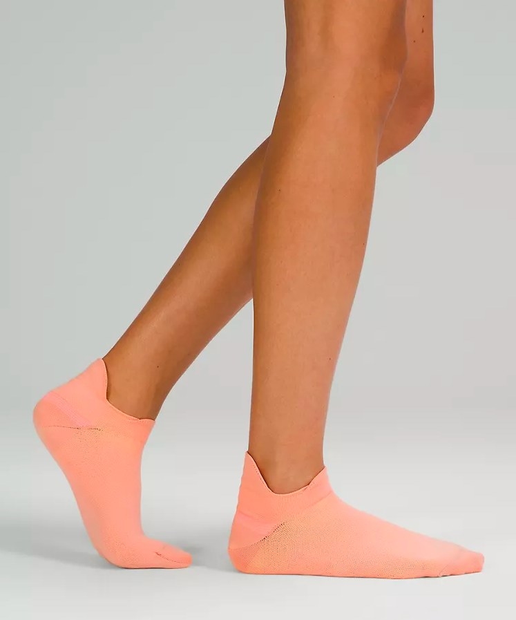 Model wearing coral running socks