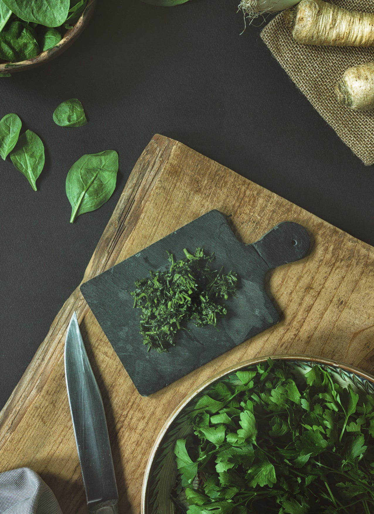 Chopped herbs on a wooden cutting board.