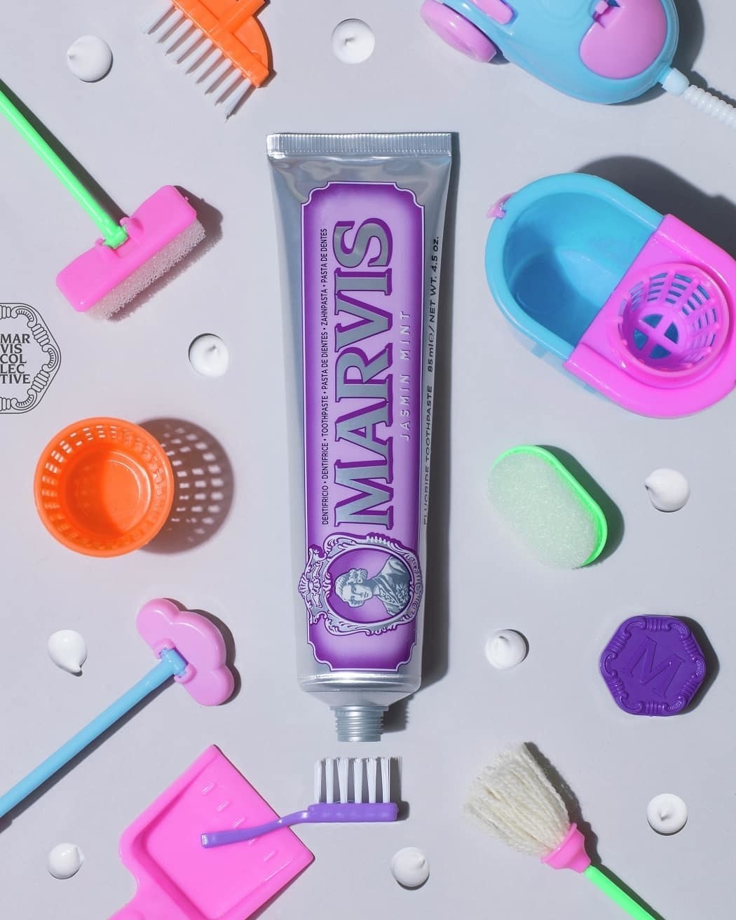 a flatlay of the tube of toothpaste surrounded by tiny plastic cleaning tools