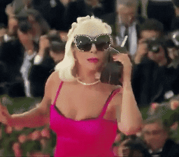 Gaga pretending to be on an 90&#x27;s oversized cellphone on the Met Gala red carpet