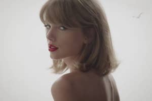 A close up of Taylor Swift as she looks over her shoulder