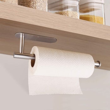 the paper towel holder mounted on the underside of a shelf