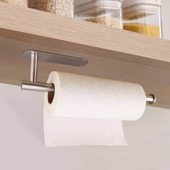 the paper towel holder mounted on the underside of a shelf