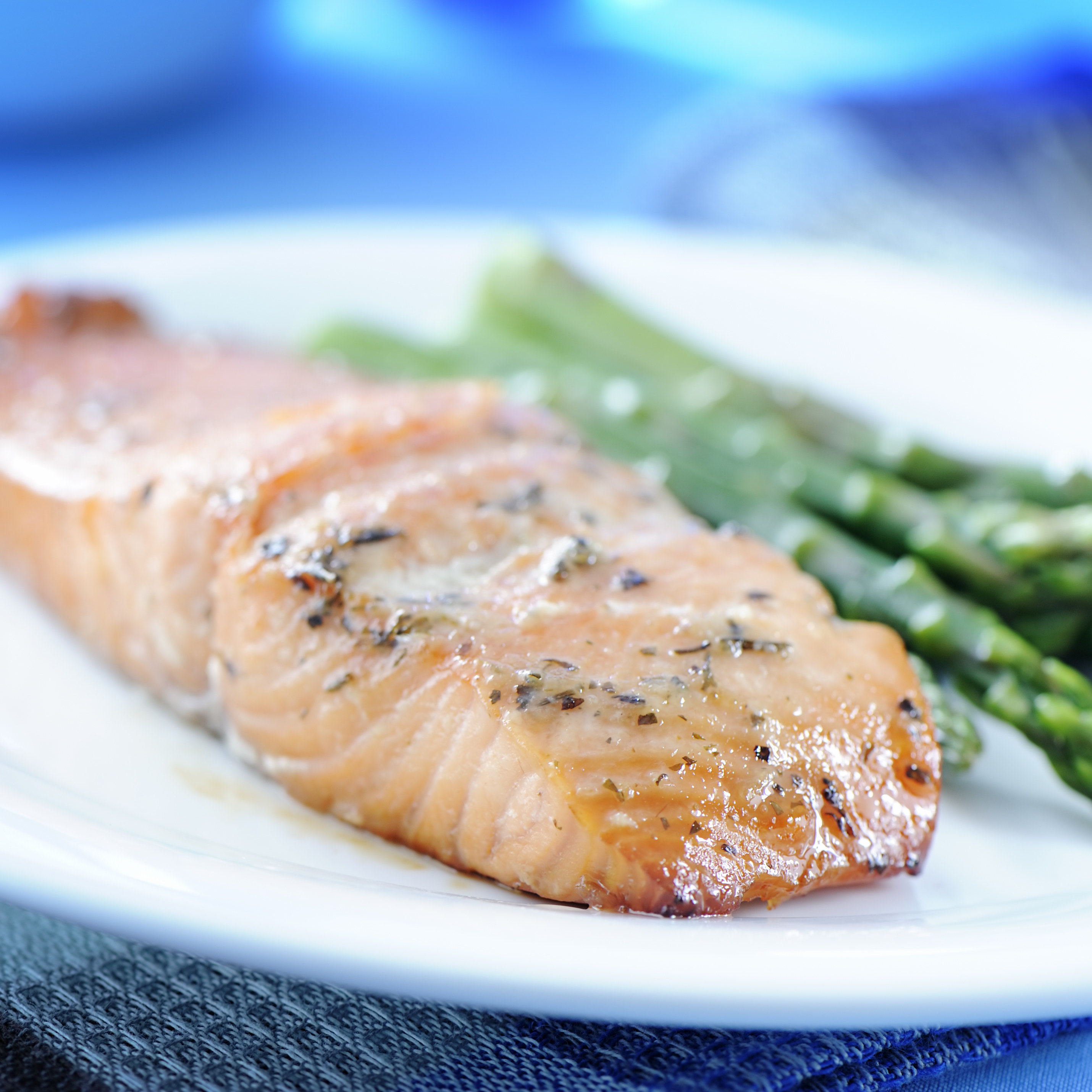 Baked salmon with asparagus in background.