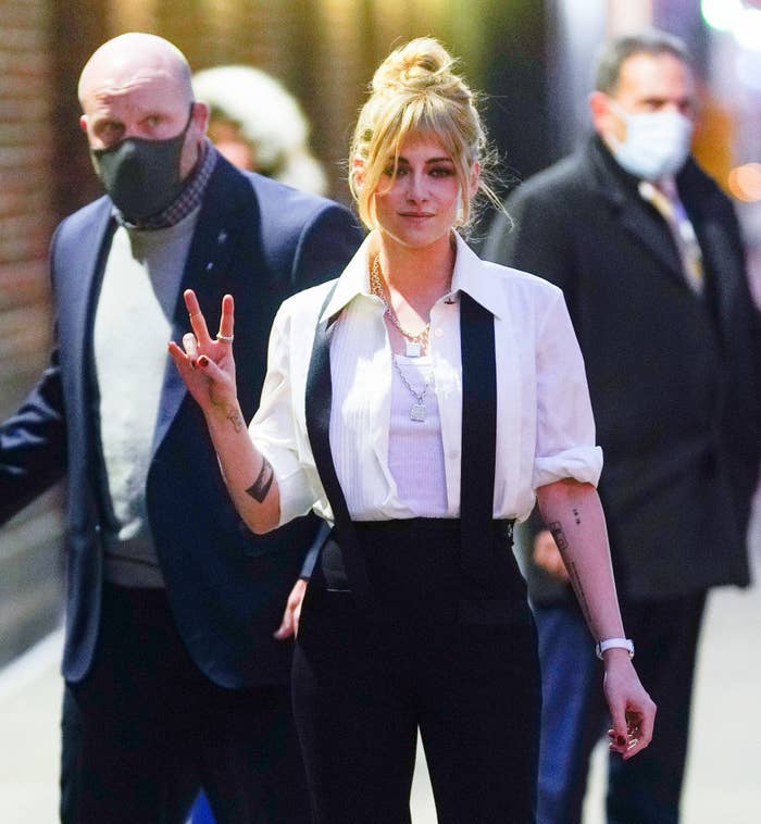 Kristen giving the peace sign as she walks outside