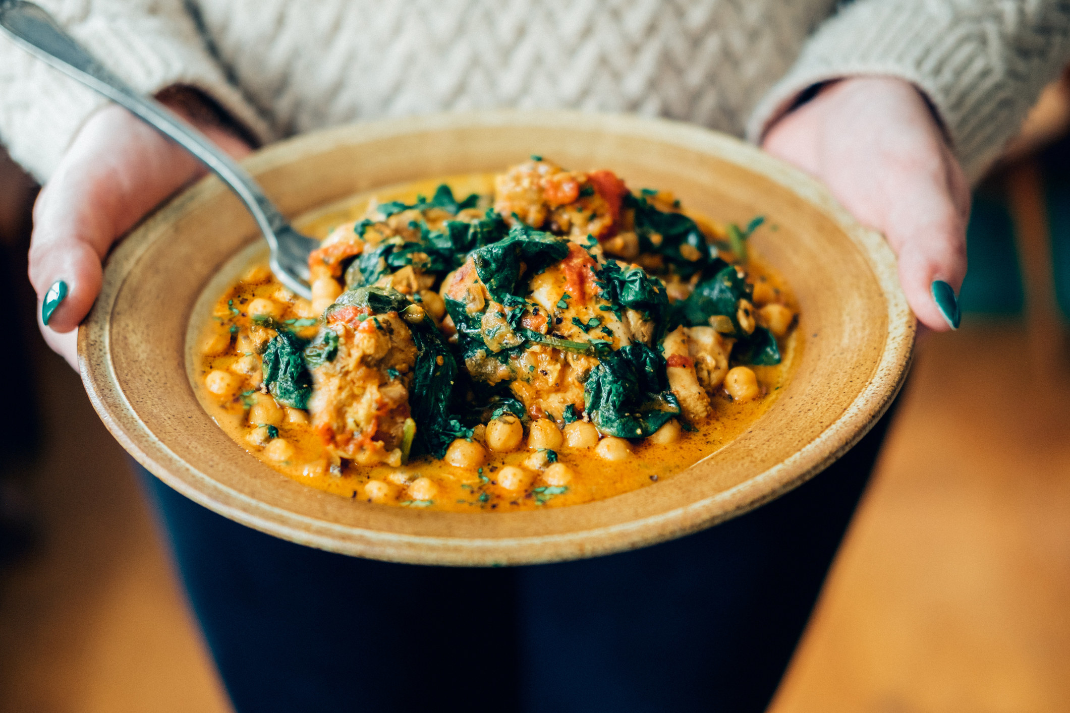 A bowl of chickpea and spinach curry.