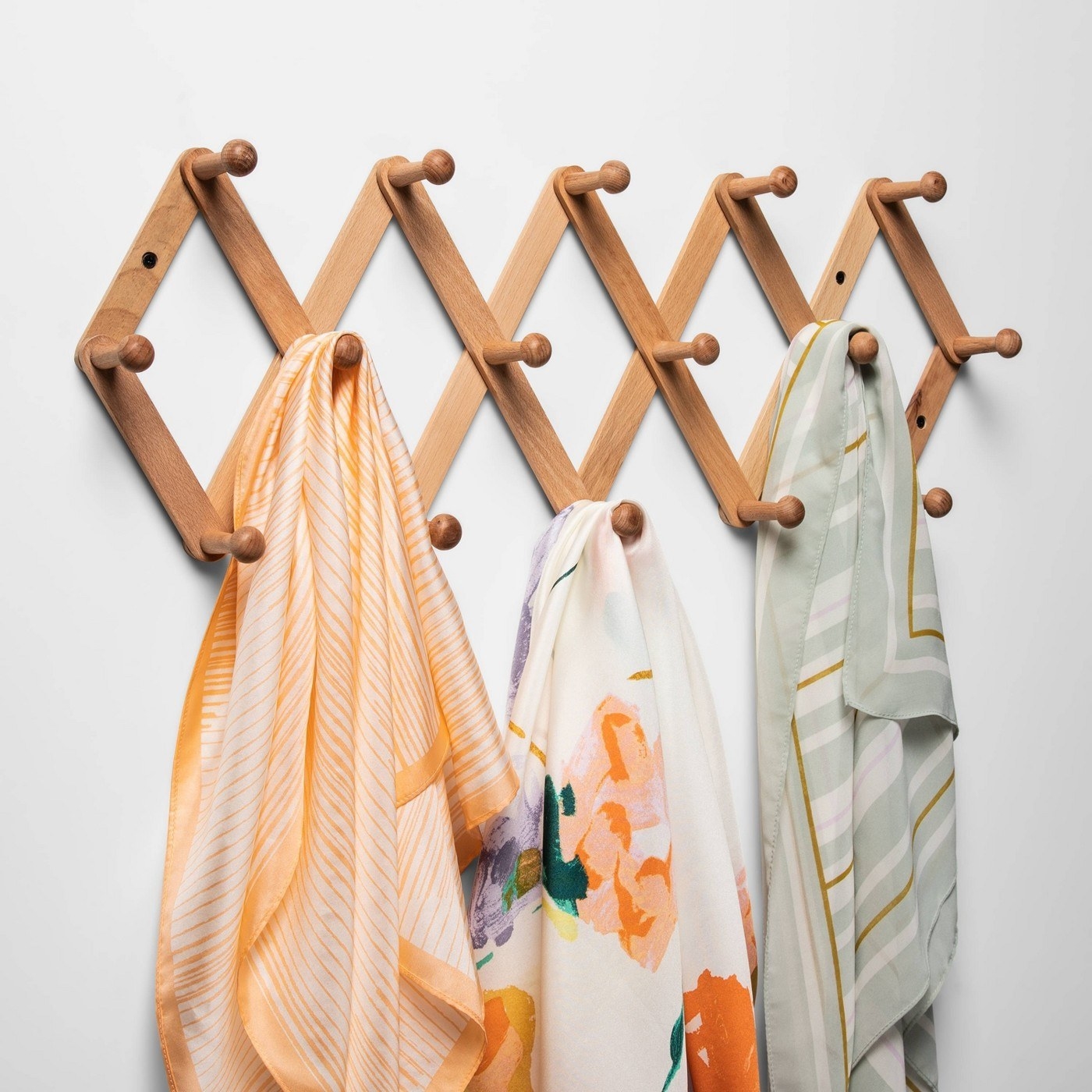 The wall hook rail with colorful scarves on it