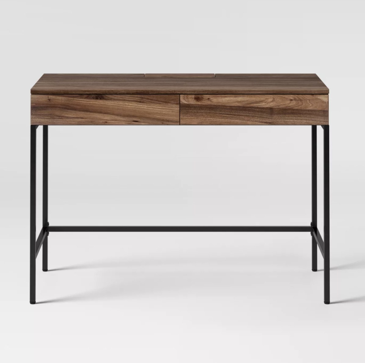 The brown wooden desk has long black legs connected at the bottom