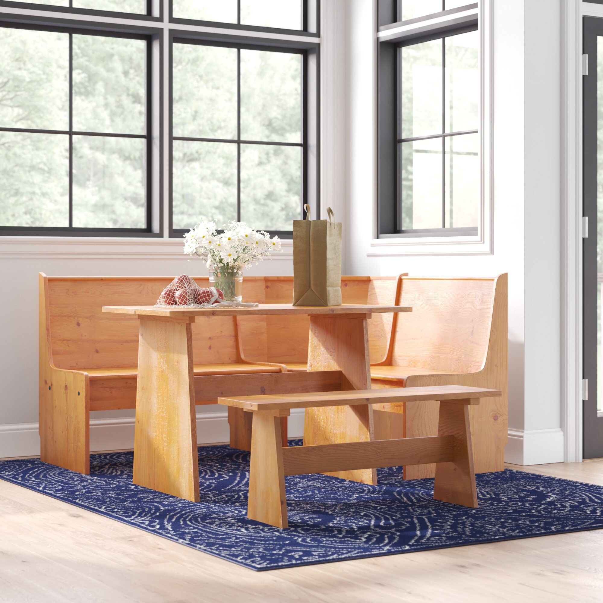 A light wood table with a bench and three connected chairs that wrap around.