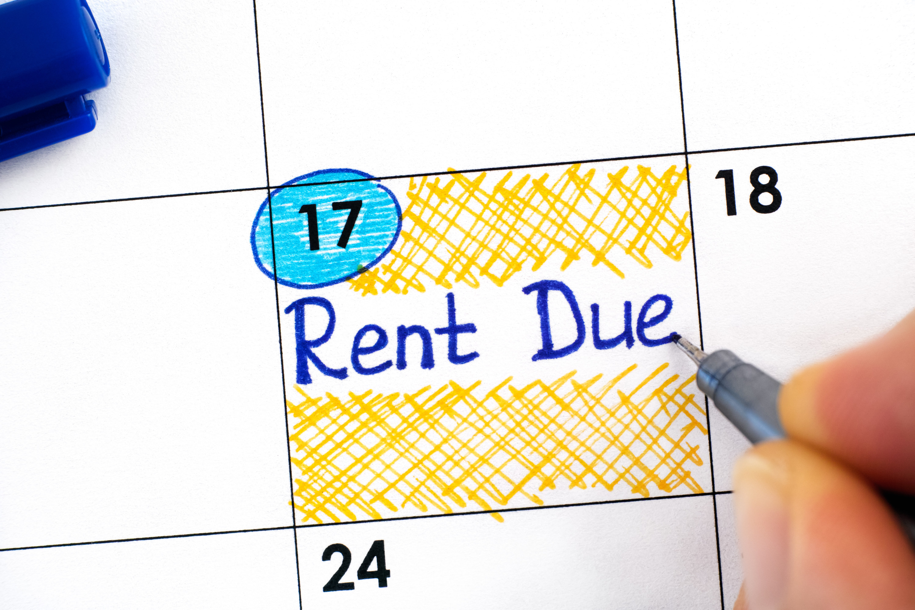 The words &quot;rent due&quot; written in blue on a calendar