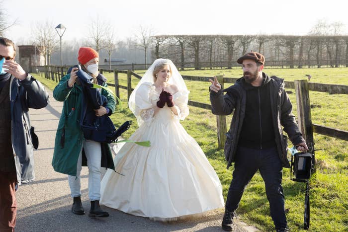 Kristen walking on set in a wedding dress