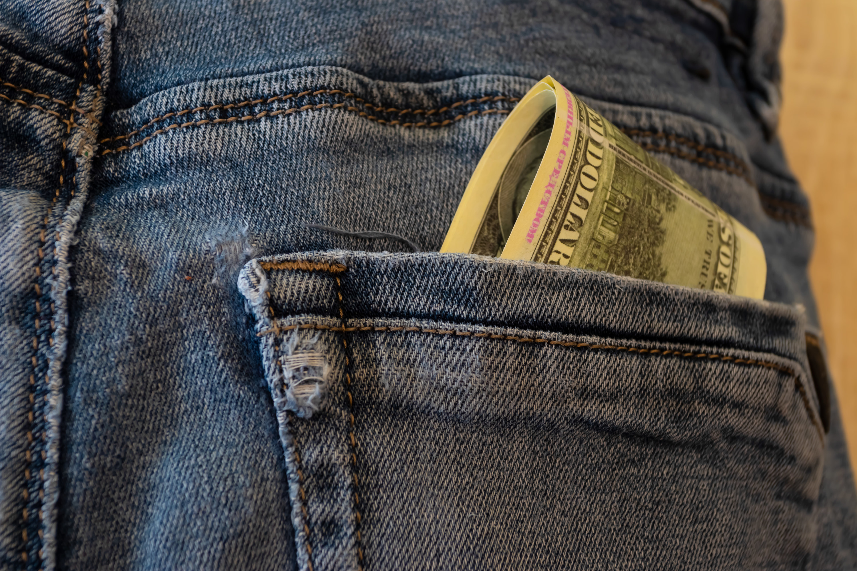 Cash folded up in the back pocket of jeans