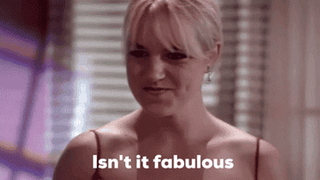 GIF of actor in red dress saying, &quot;Isn&#x27;t it fabulous&quot; in the movie &quot;The Room&quot;