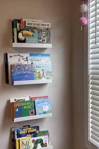 a reviewer photo of three of the shelves on the wall and filled with children's books